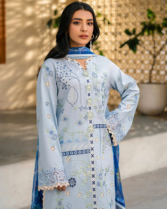 Woman wearing a light blue embroidered dress with a matching dupatta outdoors.