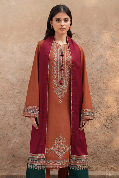 Woman wearing a traditional outfit with maroon and orange embroidery