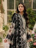 Woman wearing a black and white patterned dress in an outdoor setting with flowers and classical architecture.
