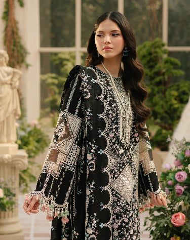 Woman wearing a black and white patterned dress in an outdoor setting with flowers and classical architecture.