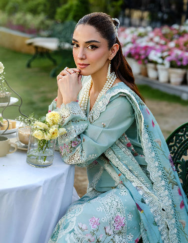 Woman in a light blue embroidered outfit. Lawn Embroidered Dress for Summer 2026