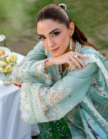 Woman in a light blue embroidered outfit. Lawn Embroidered Dress for Summer 2026