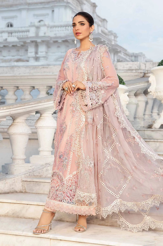 Woman in a pink embroidered traditional outfit standing on a marble staircase.